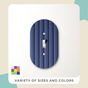 May include: A navy blue, oval-shaped light switch cover with vertical ribbed texture. The cover has a standard toggle switch and two screw holes. The text "VARIETY OF SIZES AND COLORS" is at the bottom of the image.