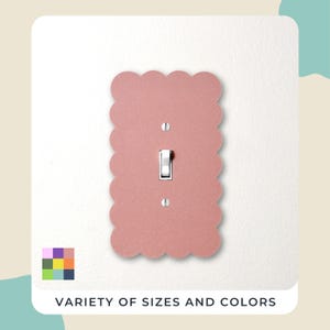 May include: A light pink, scalloped-edge light switch cover with a white toggle switch and screws. The text "VARIETY OF SIZES AND COLORS" is at the bottom. The cover is mounted on a white wall.