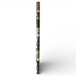 May include: A roll of gift wrap featuring a repeating pattern of various monsters in black, green, and white on a black background. The words "Monster Gift Wrap" are printed vertically in green. The roll is cylindrical and has a white background.