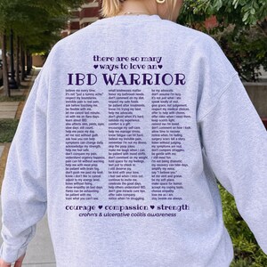 May include: A light grey sweatshirt with the text "there are so many ways to love an IBD WARRIOR" in purple. Below the text are lists of phrases and the words "courage, compassion, strength" and "crohn's & ulcerative colitis awareness".