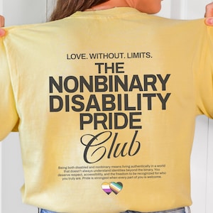 May include: A pale yellow t-shirt featuring black text that reads LOVE. WITHOUT. LIMITS. THE NONBINARY DISABILITY PRIDE CLUB. Below the text is a paragraph about living authentically and two small hearts in nonbinary and disability pride colors.