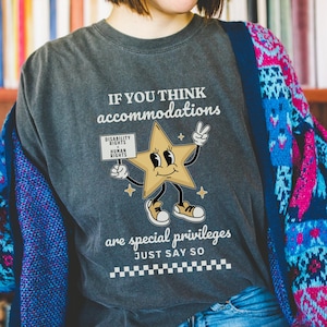 May include: A gray t-shirt with the text "If you think accommodations are special privileges just say so" and a cartoon star holding a sign that says "Disability Rights Human Rights".