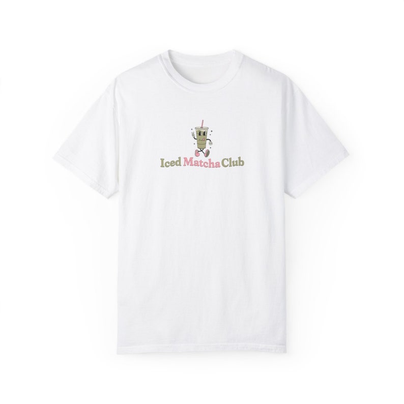May include: White t-shirt with a cartoon illustration of a green iced matcha drink with a pink straw and the text "Iced Matcha Club".