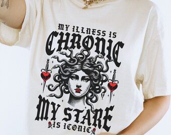 May include: White t-shirt with a black and white graphic of Medusa with the text "My illness is chronic, my stare is iconic."