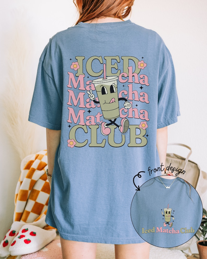 May include: A light blue oversized t-shirt with a cartoon illustration of a green iced matcha drink with the text "ICED Matcha CLUB" on the back. The front of the shirt has a smaller version of the cartoon drink with the text "Iced Matcha Club".