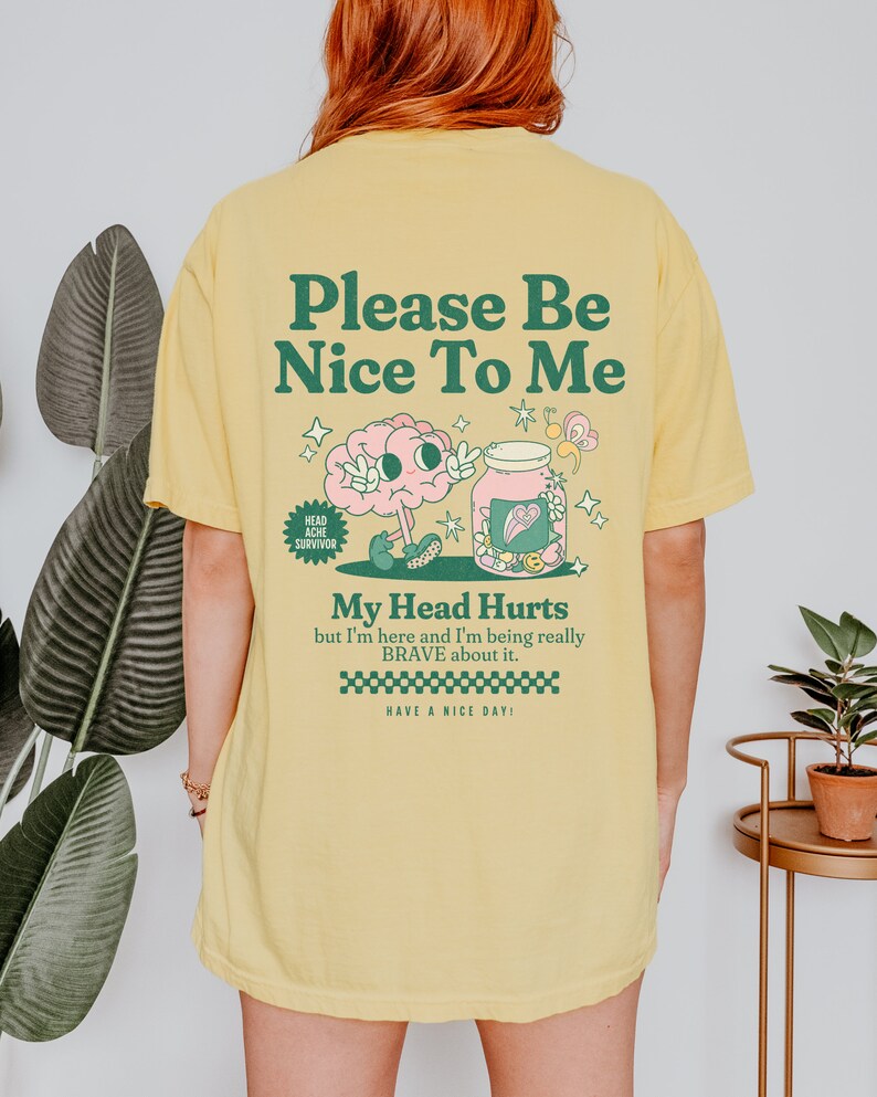 May include: Yellow t-shirt with a cartoon brain and jar design. The text on the shirt reads "Please Be Nice To Me", "My Head Hurts but I'm here and I'm being really BRAVE about it." and "Have a Nice Day!"