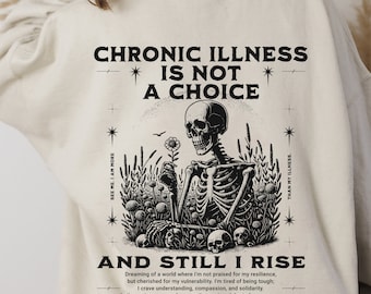 May include: A beige sweatshirt with a black graphic print of a skeleton holding a flower. The text "Chronic Illness is not a choice" and "And Still I Rise" is printed on the sweatshirt. The text below the graphic reads "Dreaming of a world where I'm not praised for my resilience, but cherished for my vulnerability. I'm tired of being tough; I crave understanding, compassion, and solidarity. Let's create a space where gentleness is celebrated as courage, and where support is our strongest armor."