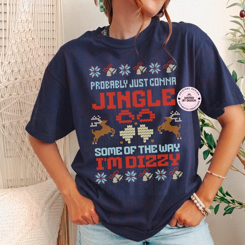 Peut inclure: T-shirt bleu marine avec un motif festif. Le texte "Probably Just Comma Jingle Some of the Way I'm Dizzy" est en rouge, bleu et blanc. Le motif comprend des rennes, des flocons de neige et des cloches.