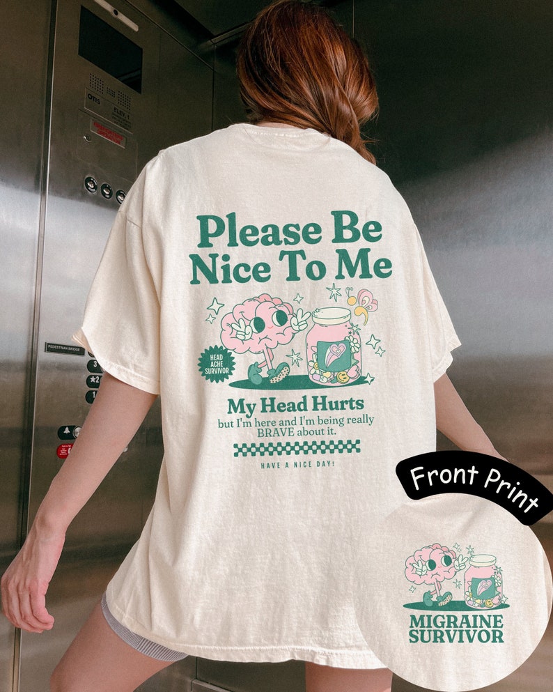 Retro migraine t-Shirt. The front has a pocket design that says Migraine Survivor with a pink brain character and a pill bottle with pills that are pastel and flower shaped. The back includes the graphic and, Please be nice to me, my head hurts