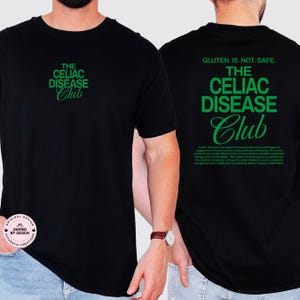 Op de afbeelding: Zwart T-shirt met groene tekst "THE CELIAC DISEASE Club" op de voor- en achterkant. De achterkant van het shirt heeft ook de tekst "GLUTEN. IS. NOT. SAFE." en een beschrijving van Coeliakie.