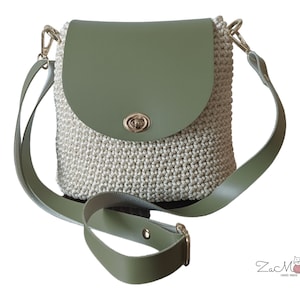 Może przedstawiać: Zielona i biała torba na ramię wykonana na szydełku z klapą skórzaną i złotym zapięciem. Torba ma długi, regulowany pasek.