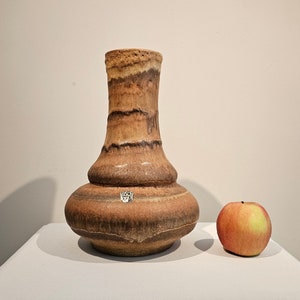 A West German Fat Lava vase made by Ruscha. The vase is brown and round in shape.