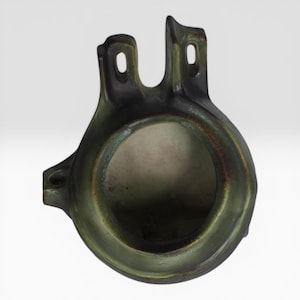 May include: A unique, handcrafted ceramic vase with a dark green and brown glaze. The vase features a circular opening and two vertical, arched handles with small holes. The design is organic and sculptural, suitable for home decor.