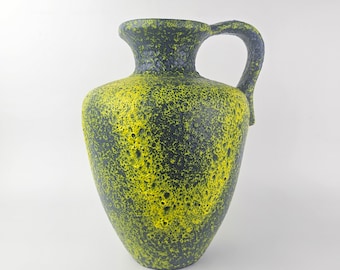 May include: A yellow and dark blue ceramic vase with a textured surface and a handle. The vase is shaped like a traditional amphora.