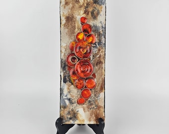 A West German Fat Lava wall plate made by Ruscha. The rectangular wall plate is brown with orange mushrooms. Number 779/2.