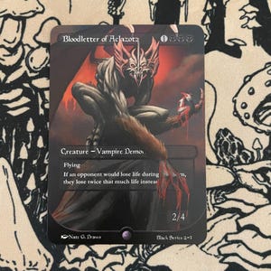 May include: A black trading card featuring a demonic creature with red accents, titled "Bloodletter of Aclazota." The card displays the creature's stats and abilities, with the artist's signature and series information at the bottom. The creature is depicted with a menacing expression.