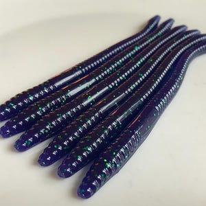 May include: A pack of eight purple and green glitter fishing worms.