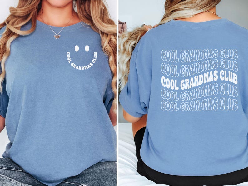 May include: A light blue t-shirt with the text "COOL GRANDMAS CLUB" on the back in white, stacked and wavy. The front features a smiley face design with the words "COOL GRANDMAS CLUB" in a semi-circle.