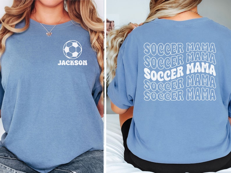 Peut inclure: Un t-shirt bleu clair avec un ballon de football blanc et le nom "JACKSON" sur le devant. Le dos du t-shirt porte la phrase "SOCCER MAMA" r&eacute;p&eacute;t&eacute;e cinq fois dans une police r&eacute;tro.