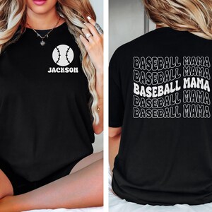 May include: Black t-shirt with a white baseball graphic and the name "Jackson" on the front. The back of the shirt has the text "Baseball Mama" repeated five times in a wavy font.