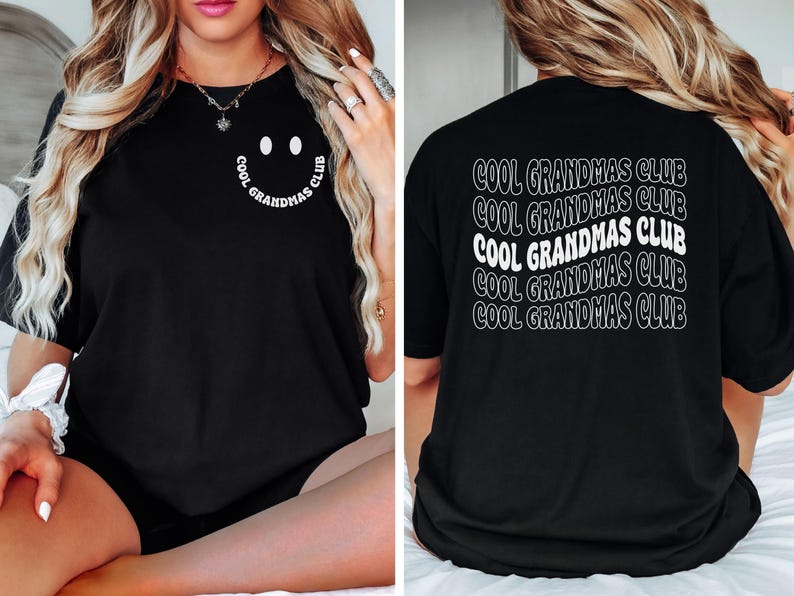 May include: Black t-shirt with the text "COOL GRANDMAS CLUB" in white. The front of the shirt features a smiley face design with the text "COOL GRANDMAS CLUB" in a circular pattern. The back of the shirt repeats the text.