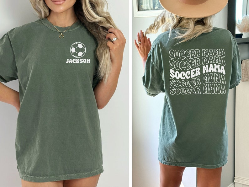 Peut inclure: Un t-shirt vert avec un ballon de football blanc et le nom "JACKSON" sur le devant. Le dos du t-shirt porte les mots "SOCCER MAMA" r&eacute;p&eacute;t&eacute;s cinq fois dans une police r&eacute;tro.