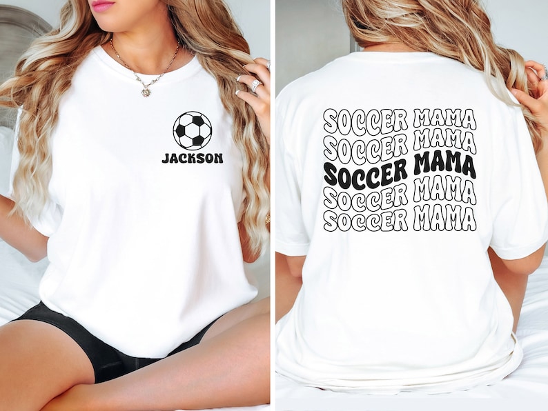 Peut inclure: T-shirt blanc avec un motif de ballon de football et le texte "Jackson" sur le devant. Le dos du t-shirt porte le texte "Soccer Mama" r&eacute;p&eacute;t&eacute; cinq fois dans une police r&eacute;tro.