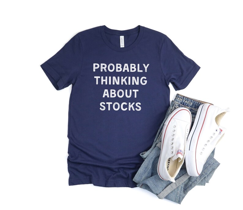 Puede incluir: Una camiseta azul marino con el texto "PROBABLY THINKING ABOUT STOCKS" en letras blancas.