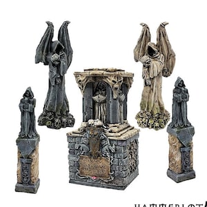 Può includere: Un set di cinque lapidi in miniatura in stile gotico, ciascuna con una figura incappucciata e dettagli intricati. La lapide centrale ha una targa con l'iscrizione "Vladimir Von DeVille 1450 - 1275".