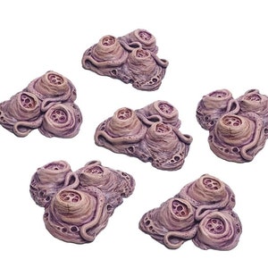 Puede incluir: Seis piezas de terreno alienígena carnosas de color púrpura y rosa con múltiples agujeros y protuberancias. Estas son piezas de terreno para juegos de mesa.