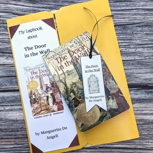 May include: A yellow folder containing a brown and white book titled "The Door in the Wall" by Marguerite De Angeli. The book is open to reveal illustrations. A brown bookmark with the text "My Lapbook about The Door in the Wall" is visible.