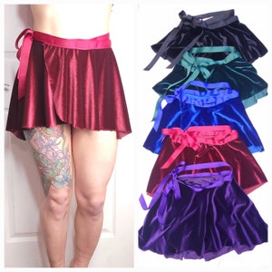 May include: Five velvet wrap skirts in different colors: black, teal, blue, burgundy, and purple. Each skirt has a matching satin ribbon tie.
