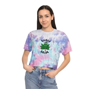May include: A tie-dye cropped t-shirt with a green marijuana leaf wearing a flower crown and the text "Baked Bride".