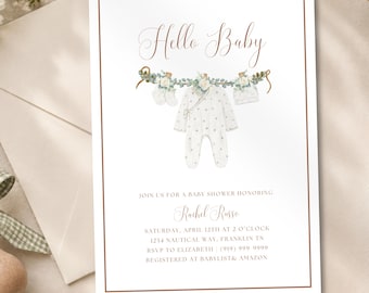 May include: A white baby shower invitation card with a copper border featuring the text Hello Baby and a watercolor illustration of a baby onesie, socks, and a hat hanging from a greenery garland, with event details for Rachel Russo on April 12th.