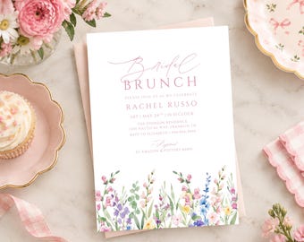 May include: A white rectangular invitation card with pink text reading Bridal Brunch, Rachel Russo, and event details. The bottom features a watercolor illustration of colorful wildflowers in shades of pink, blue, yellow, and green on a light background.