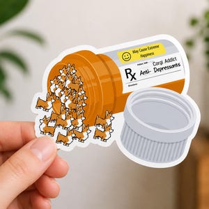 May include: A sticker featuring a cartoon pill bottle with the text "Corgi Addict Anti-Depressants." The bottle is orange, with a white label and a gray cap. Corgi dogs are spilling out of the bottle. The label reads "May Cause Extreme Happiness."