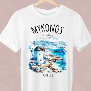 Może przedstawiać: Biała koszulka z czarnym nadrukiem graficznym wiatraka i tekstem "Mykonos is calling and I must go Greece".