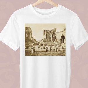 以下が含まれることがあります： 古代の遺跡の白黒写真。写真は、柱とアーチのある大きな石造りの構造物を示しています。遺跡は瓦礫と残骸に囲まれています。