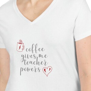 May include: White V-neck t-shirt with the text "coffee gives me teacher powers" in grey lettering and a red heart. A red coffee cup with steam and a lightning bolt is above the text.