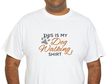 以下が含まれることがあります： オレンジ色の「This is my Dog Walking Shirt」の文字と灰色の肉球のプリントがされた白いTシャツです。