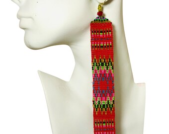 Pendientes colgantes artesanales de cuentas rojas con detalles en oro verde.