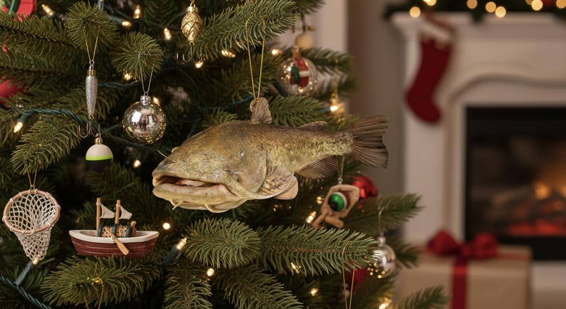 Puede incluir: Un &aacute;rbol de Navidad decorado con adornos tem&aacute;ticos de pesca, incluyendo un pez, se&ntilde;uelos, un peque&ntilde;o barco y bolas brillantes. El &aacute;rbol est&aacute; iluminado con peque&ntilde;as luces blancas, creando una escena festiva navide&ntilde;a.
