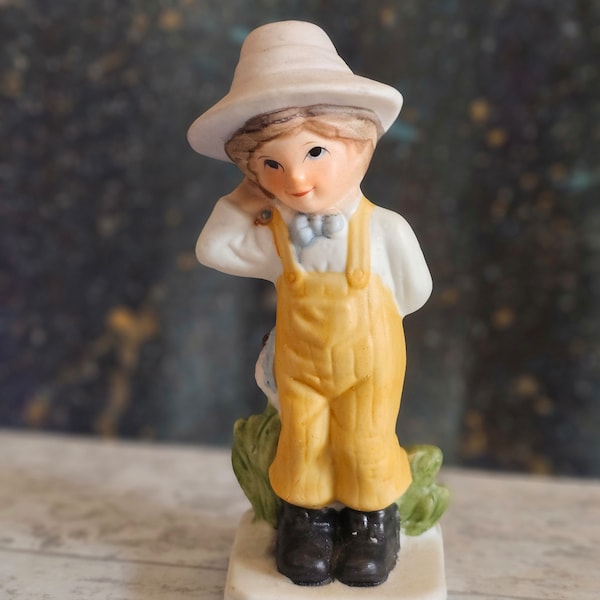 Vintage Porcelain Figurine Boy In Overalls With Hat And Bow-tie Hiding Flowers Behind His Back