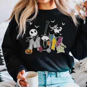 May include: Black sweatshirt with a graphic print of characters from the Nightmare Before Christmas movie. The characters are arranged to spell out the word "MOM".