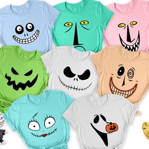 May include: A collection of eight short-sleeved t-shirts in various colours, each featuring a different character face graphic. The shirts include light blue, green, pink, lime, white, peach, teal, and white, alongside a small plush toy.