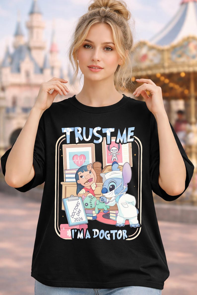 Pu&ograve; includere: T-shirt nero con grafica a cartoni animati di Lilo e Stitch a tema medico. La maglietta presenta la scritta "TRUST ME I'M A DOCTOR" in bianco e blu. Il design include illustrazioni mediche e la scritta "DOCTORS DAY 2026".