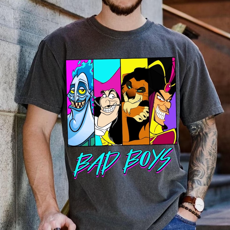 May include: Dark gray t-shirt featuring a colorful graphic of four cartoon villains: Hades, Captain Hook, Scar, and Jafar. The words "BAD BOYS" are printed in a teal and pink font below the characters.