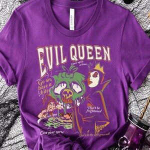 May include: Purple t-shirt with a graphic print of the Evil Queen from Snow White. The graphic includes the text "Evil Queen", "Once upon a time...", "Go on, have a bite", "Cast your curse", "Don't be frightened", and "Don't let the wish grow cold".