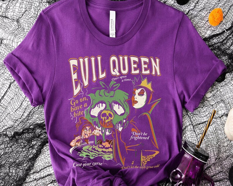 May include: Purple t-shirt with a graphic print of the Evil Queen from Snow White. The graphic includes the text "Evil Queen", "Once upon a time...", "Go on, have a bite", "Cast your curse", "Don't be frightened", and "Don't let the wish grow cold".