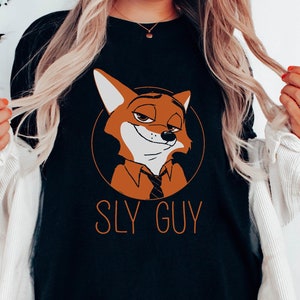 May include: Black long-sleeved top with a cartoon fox character in an orange circle. The fox has a sly expression and is wearing a tie. The text "SLY GUY" is printed below the fox in orange.